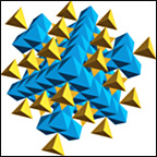 Small square outline surrounding geometric crystal structure showing clusters of yellow and blue tetragonal shapes.