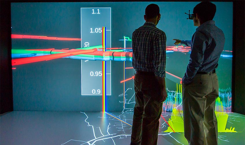 34487-technoecon-848 Two people looking at a data visualization projected on a screen